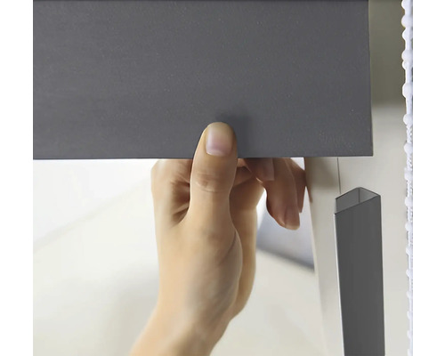 Eine Person befestigt eine Jalousie.