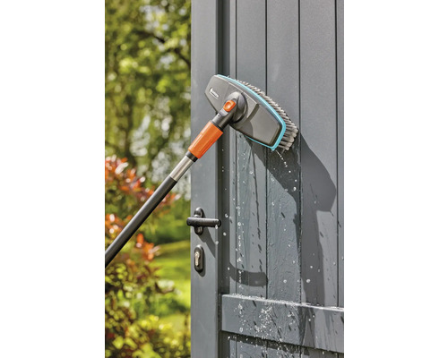 Gardena Waschbürste mit Teleskopstiel reinigt eine Gartentür