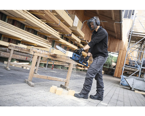 Mann mit Schutzvisier sägt Holz mit einer Bosch Säge