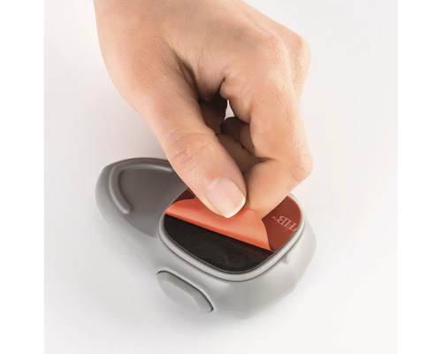 Hand entfernt Schutzfolie von einem Klebehaken.