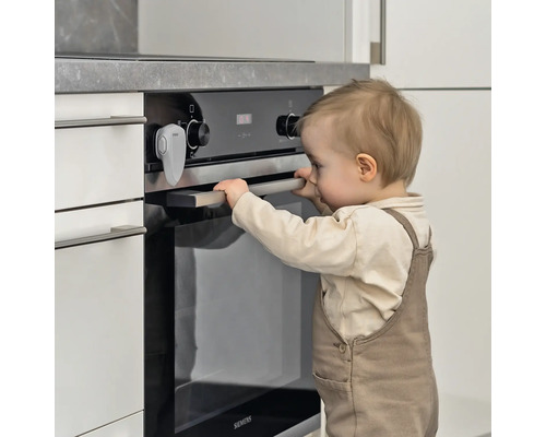 Kind versucht, einen Ofen mit Kindersicherung zu öffnen