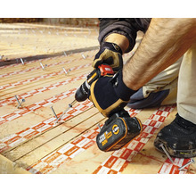 Handwerker befestigt Holzdiele mit einem Akkubohrer