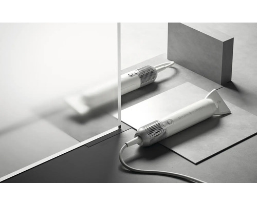 Zwei Haartrockner mit Düsenaufsatz auf einem strukturierten Untergrund