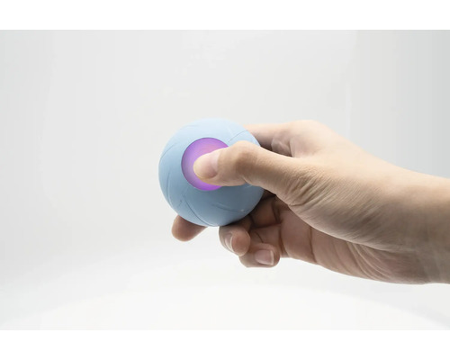 Eine Hand hält einen blauen Therapieball mit LED-Licht.