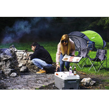 Zwei Personen campen mit Zelt, Kühlbox, Campingstühlen und Grill