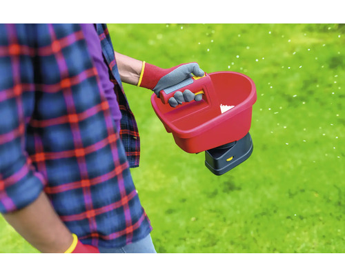 Person verwendet Handstreuer für die Rasenpflege.