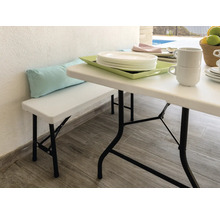 Szene mit Gartentisch, Gartenbank und Geschirr auf einer Terrasse