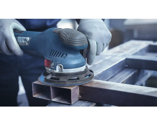 Handwerker schleift Metall mit einem Exzenterschleifer.