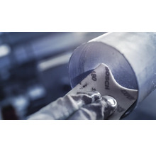 Schleifen eines Metallrohrs mit Schleifpapier der Körnung 180