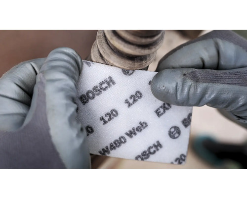 Eine Person schleift mit einem Bosch Schleifvlies, Körnung 120, ein Werkstück.