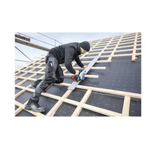 Ein Handwerker sägt mit einer Handkreissäge auf einem Dach.