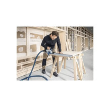 Handwerker sägt Holzplatte mit einer Handkreissäge auf einer Werkbank