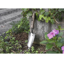 Edelstahllöffel mit Holzgriff im Gartenbeet
