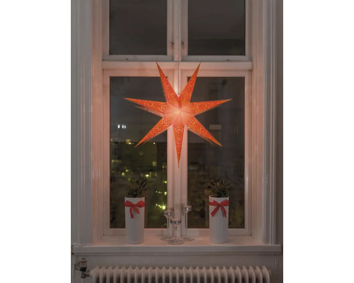 Dekoratives Fenster mit beleuchtetem Papierstern, Topfpflanzen und Kerzenständern