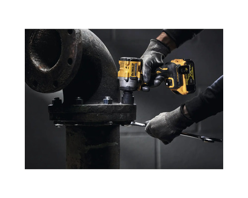 Ein Handwerker verwendet einen Akku-Schlagschrauber der Marke DeWalt, um eine Rohrverbindung zu befestigen.