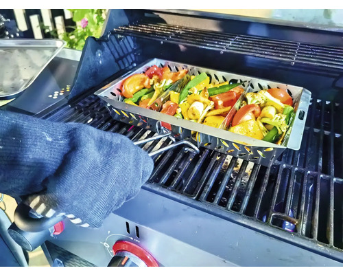 Gemüse in einer Grillpfanne auf einem Grill, der von einer Person mit einem Ofenhandschuh gehalten wird