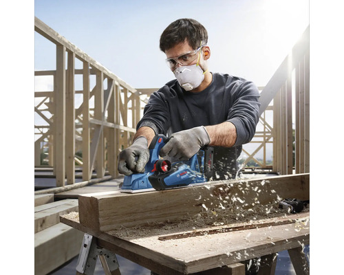 Handwerker benutzt einen Bosch Elektrohobel zum Hobeln eines Holzstücks.