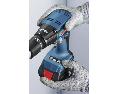 Eine Person in Handschuhen hält einen Akku-Trockenbauschrauber.