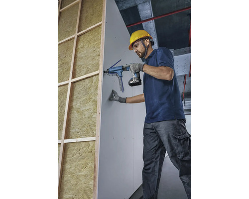 Handwerker befestigt Gipskartonplatte mit einem Magazinschrauber an einer Wand