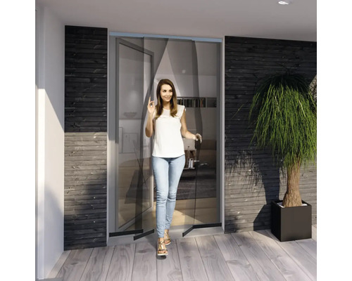 Frau geht durch eine Insektenschutztür in einem modern gestalteten Raum