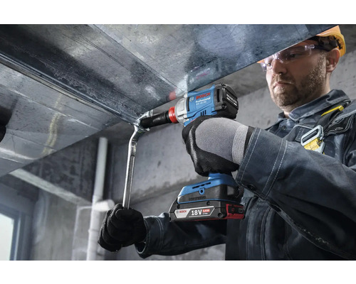 Ein Handwerker befestigt ein Bauteil mit einem Akku-Drehschlagschrauber von Bosch.