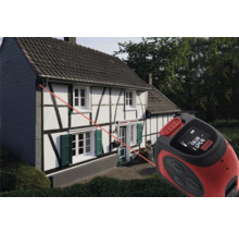 Laser-Entfernungsmesser im Einsatz vor einem Haus zur Messung von Distanzen