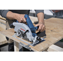 Eine Person schneidet eine Holzplatte mit einer Handkreissäge der Marke Bosch.