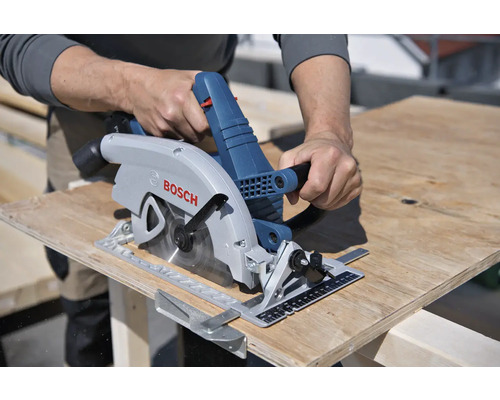 Eine Person schneidet eine Holzplatte mit einer Handkreissäge der Marke Bosch.