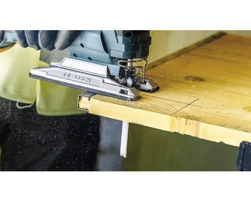 Eine Stichsäge der Marke Bosch schneidet ein Holzbrett.