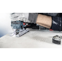 Eine Stichsäge im Einsatz beim Schneiden eines Werkstücks, bedient von einer Person mit Arbeitshandschuhen.