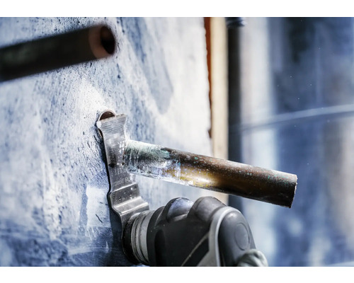 Eine oszillierende Säge schneidet ein Kupferrohr.