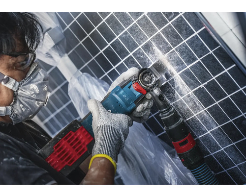 Mann arbeitet mit einem Multifunktionswerkzeug an Fliesen