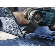 Nahaufnahme eines Multitools beim Schneiden von Dachpappe.