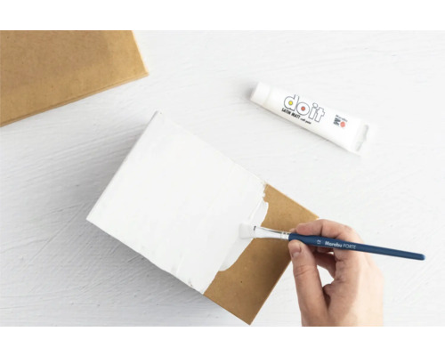 Anstreichen einer Pappschachtel mit Farbe und einem Pinsel.