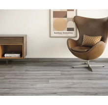 Heller Raum mit Vinylboden in Holzoptik, Sessel und Kommode