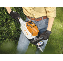 Eine Person benutzt eine Stihl Akku Heckenschere im Garten.