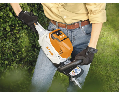 Eine Person benutzt eine Stihl Akku Heckenschere im Garten.