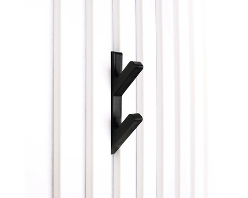 Schwarzer Kleiderhaken mit zwei Armen an einer weißen Wand.