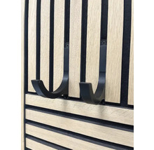 Nahaufnahme einer Holzpaneelwand mit zwei schwarzen Haken zur Aufbewahrung