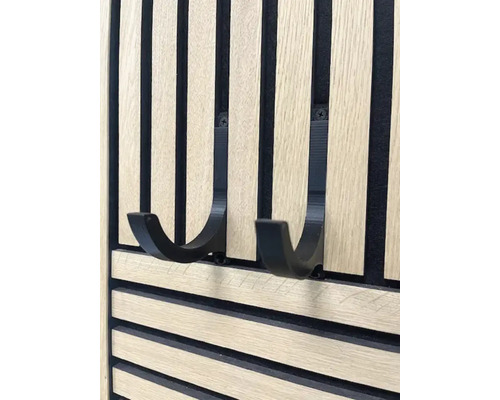 Nahaufnahme einer Holzpaneelwand mit zwei schwarzen Haken zur Aufbewahrung