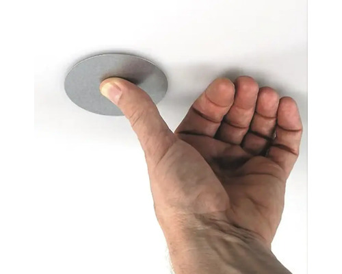 Hand berührt runde Abdeckung an Decke