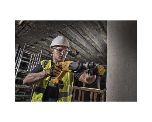 Bauarbeiter bohrt mit einem Bohrhammer in eine Wand
