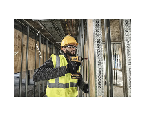 Ein Bauarbeiter mit Schutzhelm und Schutzbrille verwendet einen Akku-Schlagschrauber an einer Baustelle.