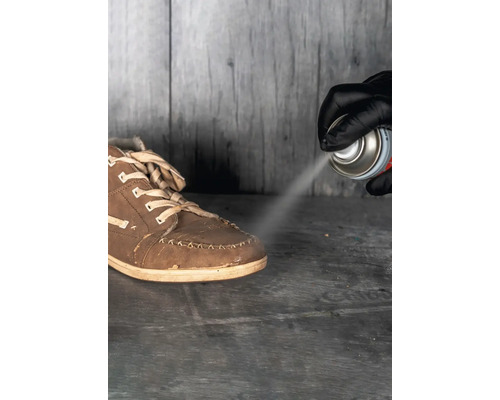 Schuh wird mit Imprägnierspray behandelt