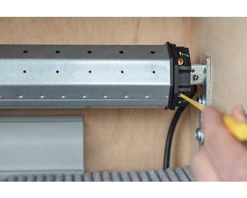 Rollladenmotor wird mit einem Schraubendreher eingestellt.