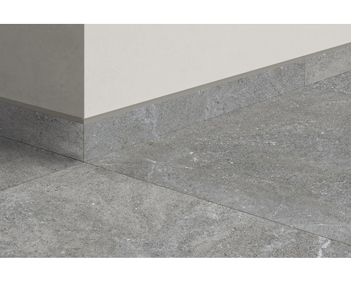 Graue Bodenfliesen und Sockelleisten an einer Wand