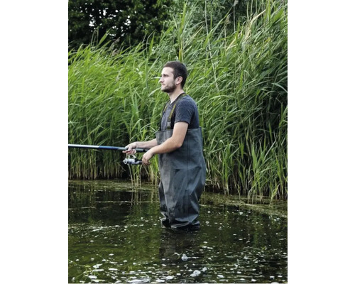 Angler mit Wathose und Angelrute im Wasser