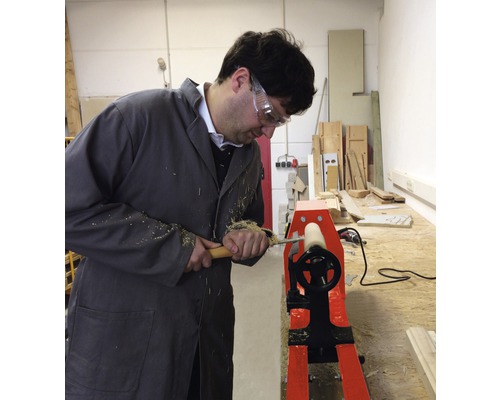 Ein Mann arbeitet mit einer Drehbank zur Holzbearbeitung.