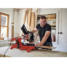 Mann mit Schutzbrille arbeitet mit einer Einhell Kapp- und Gehrungssäge in einer Werkstatt.