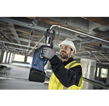 Ein Handwerker verwendet eine Akku-Presszange von Bosch zum Verpressen eines Metallrohrs.